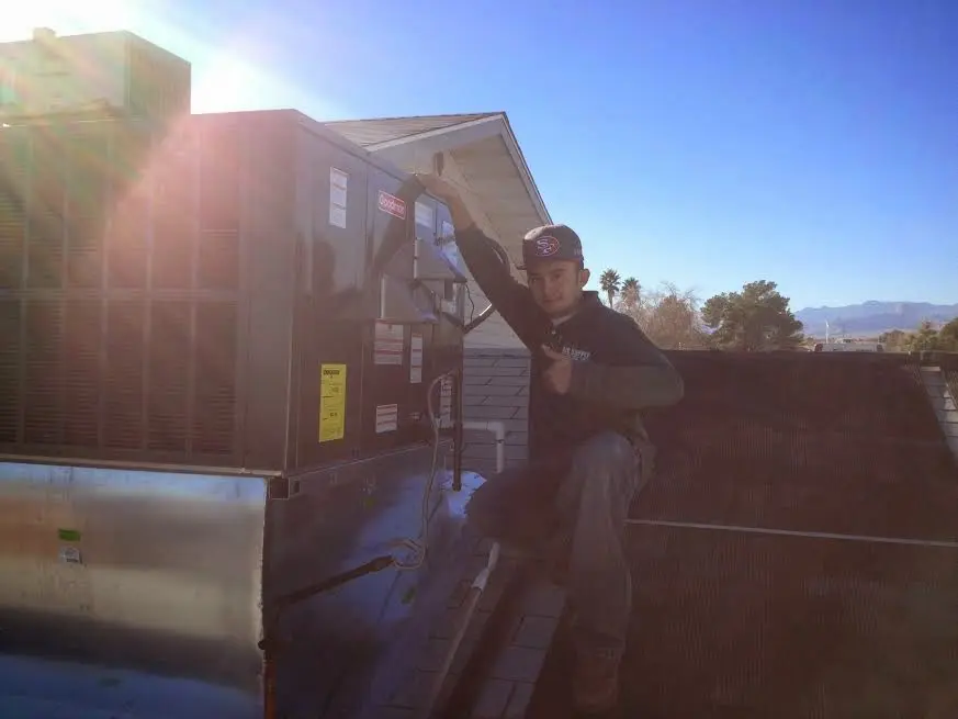 HVAC technician performing Heat Pump Repair on a rooftop unit in Gilbert